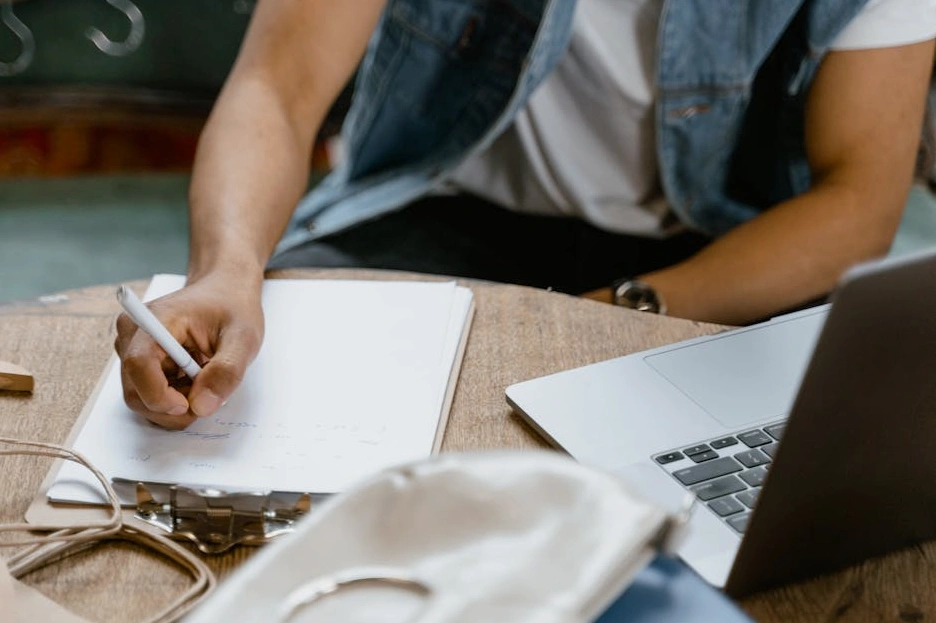 Persona che scrive su un taccuino durante una sessione di pianificazione.